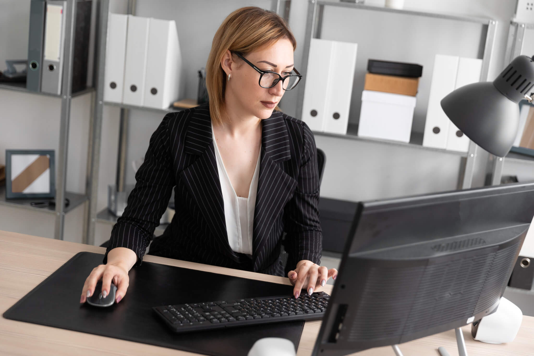 A young girl working at a computer in the office.