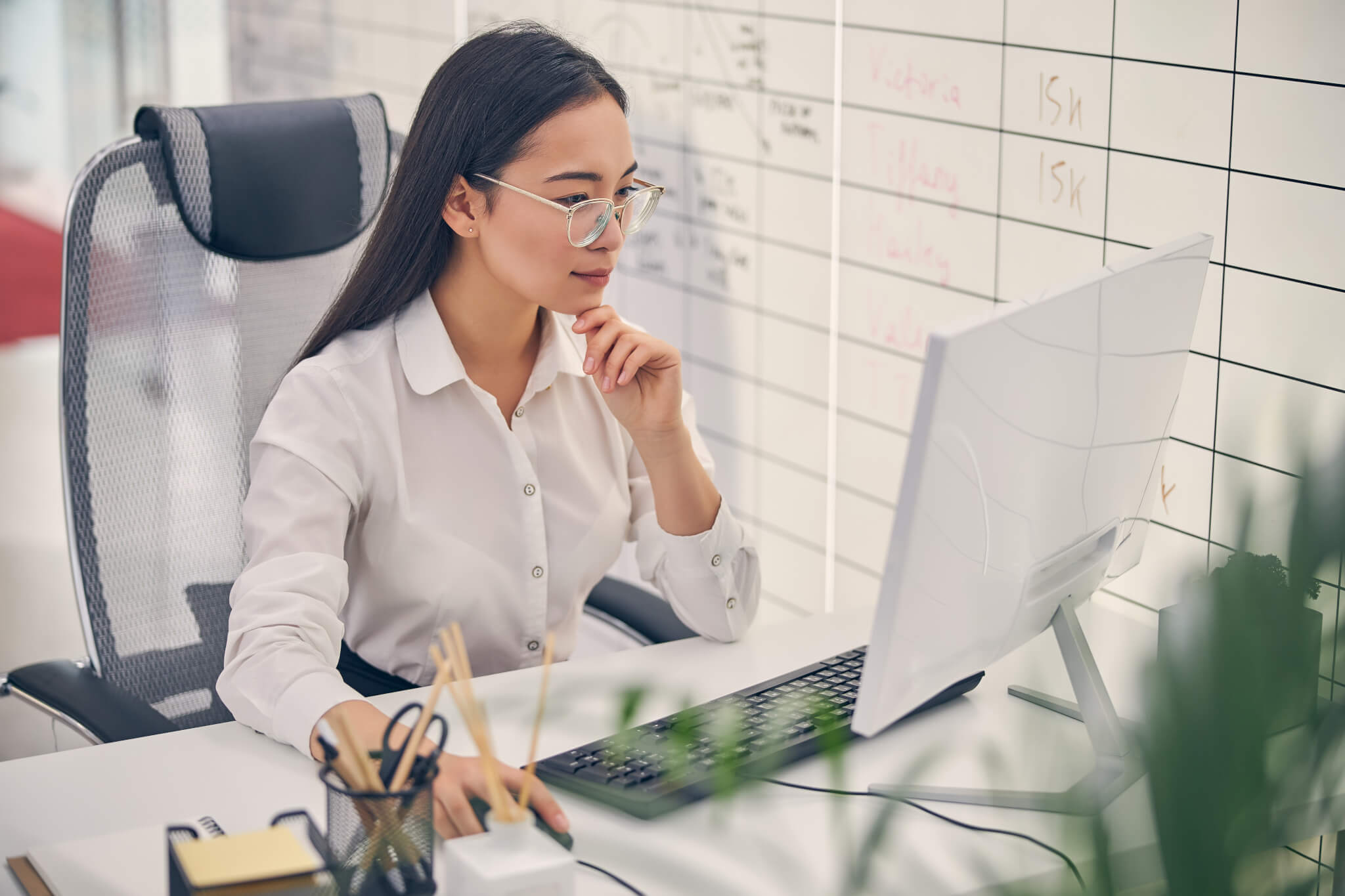 Attentive international female person working at computer