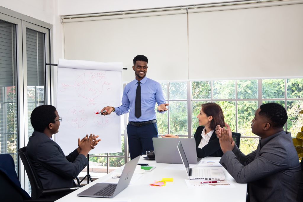 People at the office having a business meeting near an accountability board